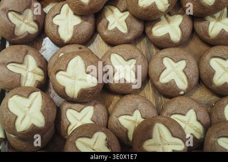 Biscuits cuits au four avec motif croix sur plateau en bois Banque D'Images