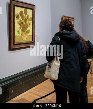 Londres, Royaume-Uni – les visiteurs regardant « tournesols » de Vincent van Gogh (1888) depuis un angle latéral Banque D'Images