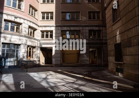 Cour intérieure et entrée d'un complexe d'appartements résidentiels du milieu du siècle à Barcelone présentant une architecture fonctionnaliste et pavée commune Banque D'Images