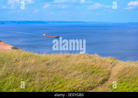 Un remorqueur articulé et un vraquier à barge transportent du sable et des matériaux de construction sur la rivière. La grande barge navigue le long de la large rive de la Volga Banque D'Images