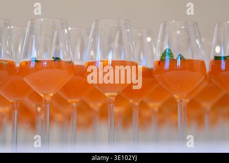 Rangées de cocktails de bienvenue avec jus d'argousier et menthe fraîche servis dans des verres à vin lors d'un événement traiteur. Boissons rafraîchissantes de bienvenue à l'argousier. Banque D'Images