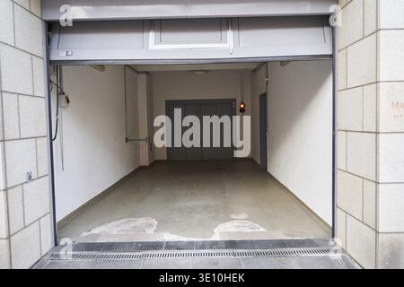 Porte de garage entrée au parking souterrain utner bâtiment résidentiel, garage ouvert avec plancher de béton, salle industrielle Banque D'Images