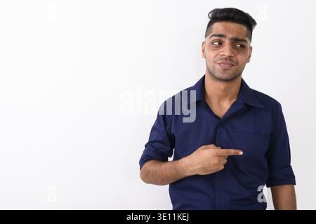 Portrait de jeune homme d'affaires indien doigt tout en regardant irrité contre fond blanc Banque D'Images