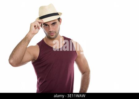 Studio shot of young handsome Young man holding hat sur tete isolés contre fond blanc Banque D'Images