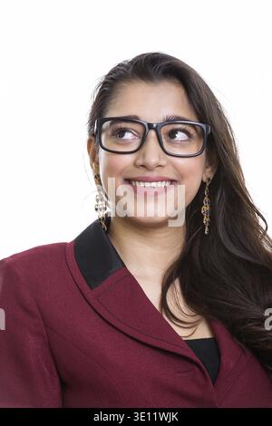 Young happy Indian businesswoman smiling en pensant et looking up Banque D'Images
