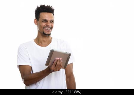 Young happy African man smiling while holding digital tablet Banque D'Images