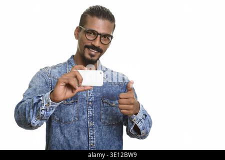 Young happy Indian man taking photo avec téléphone mobile et giving thumb up Banque D'Images