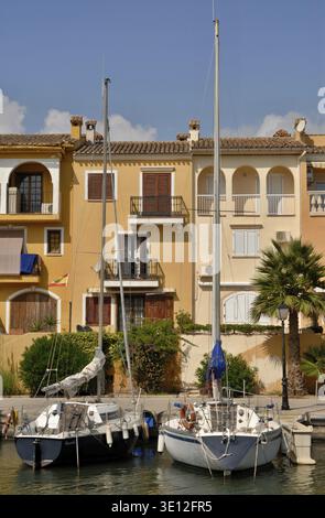 Deux voiliers sont amarrés devant une rangée de maisons colorées avec balcons à Portocolom, Majorque, Espagne Banque D'Images