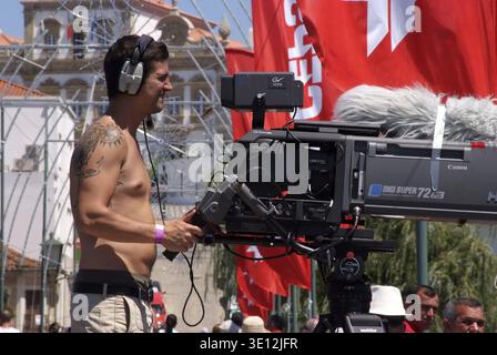 Cameraman exploitant une caméra professionnelle avec un boom sonore lors d'un événement extérieur Banque D'Images
