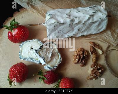 Délicieux fromage de chèvre avec fraise et noix, vue de dessus Banque D'Images