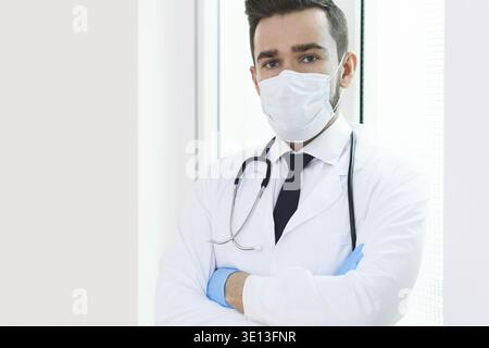 Médecin jeune et confiant portant un masque de prévention à l'hôpital Banque D'Images