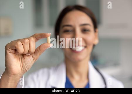 Gros plan d'un médecin féminin souriant tenant une capsule Banque D'Images