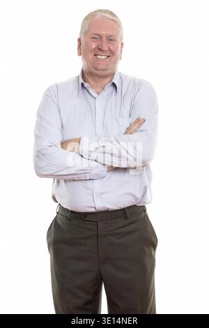 Portrait of senior man smiling and standing with arms crossed Banque D'Images