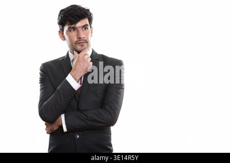Studio shot of young businessman thinking perse et à la recherche à distance Banque D'Images