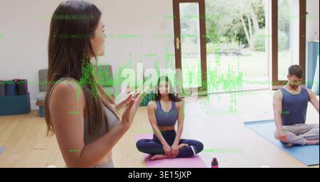 Instructeur parlant dans le cours de guidage de vêtements de sport sur tapis près de portes vitrées, recouvrement vert, espace de copie Banque D'Images