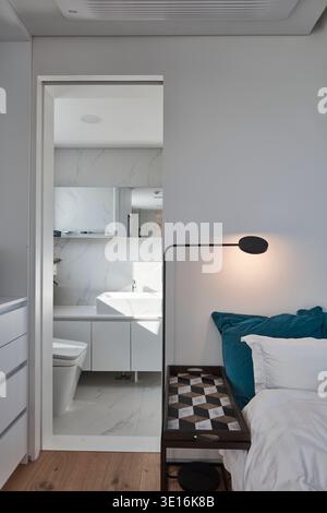 Porte de la chambre avec literie bleue et armoires encastrées blanches. Banque D'Images