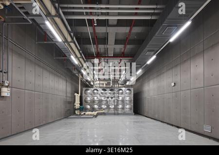 Couloir utilitaire avec services exposés à l'intérieur d'un bâtiment moderne. Banque D'Images