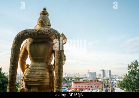 Grottes de Batu, Malaisie – 3 février 2020 : la statue du Seigneur Murugan est vue de derrière et surplombe un horizon urbain près du complexe du temple des grottes de Batu. Banque D'Images