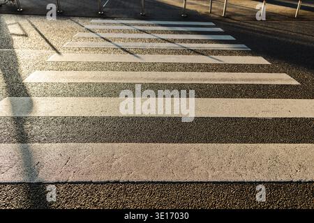 Passage piétonnier Zebra avec des bandes blanches sur la rue asphaltée de la ville en Allemagne Banque D'Images