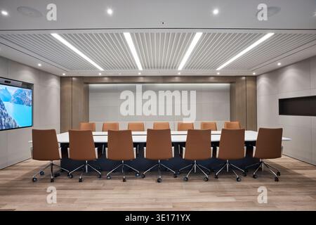 Salle de réunion moderne avec grande table de conférence et écran. Banque D'Images