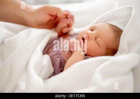 Papa tenant la main de sa fille S nouveau-né dans Une couverture blanche Banque D'Images