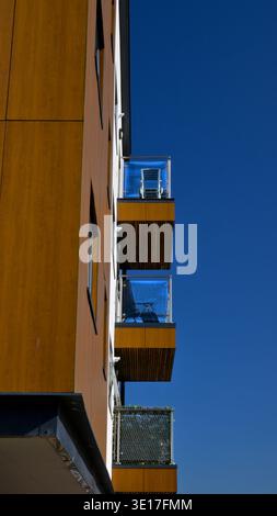 Immeuble d'appartements dans un quartier résidentiel montrant des balcons sur un ciel bleu profond. Banque D'Images