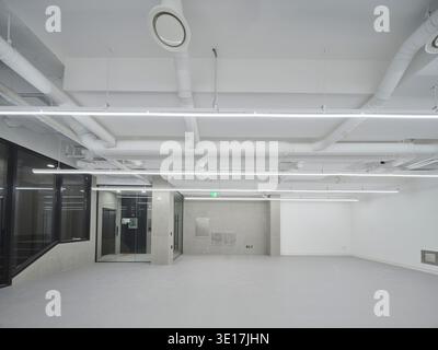 Hall de bureau blanc avec services exposés et sol poli. Banque D'Images