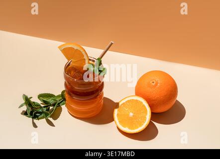 Un citron glacé rafraîchissant Americano servi dans un verre avec des glaçons, et garni d'une tranche d'orange fraîche et de feuilles de menthe, avec entier et slic Banque D'Images