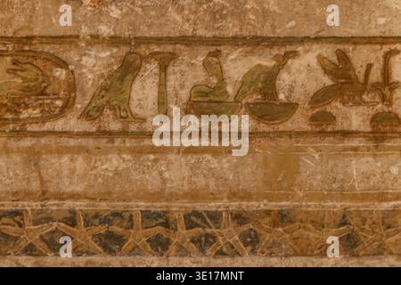 Hiéroglyphes égyptiens antiques sculptés sur le mur de pierre Banque D'Images