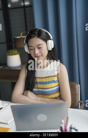 Femme asiatique utilisant un ordinateur portable pour étudier étudiant engagé dans l'apprentissage en ligne Banque D'Images