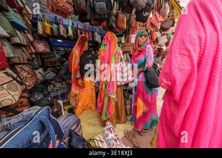 Une ruelle étroite à Pushkar Mela est bordée de boutiques vendant des sacs cousus à la main vibrants, des sacoches en cuir et des sacs à dos aux motifs brillants. Pushkar R Banque D'Images