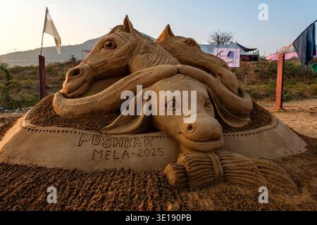 Une sculpture de sable complexe à la Foire du chameau de Pushkar, montre les têtes de deux chevaux et un chameau au-dessus du texte Pushkar Mela 2025. Pushkar Rajastha Banque D'Images