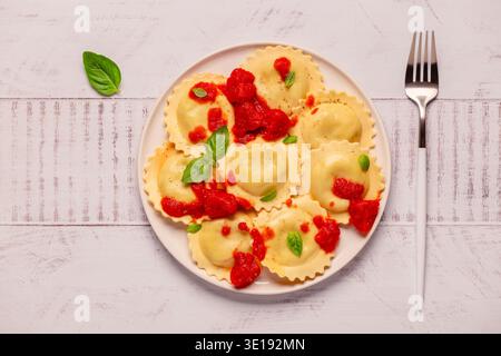 Raviolis avec sauce tomate et basilic sur assiette blanche. Banque D'Images