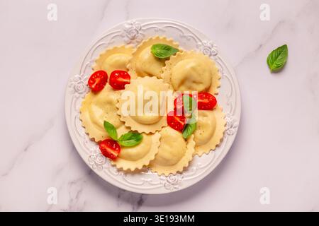 Raviolis avec sauce tomate et basilic sur assiette blanche. Banque D'Images