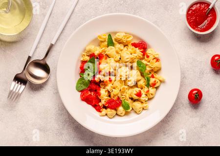 Pâtes italiennes farcies. Sacсhettini pâtes dans une assiette avec sauce tomate. Banque D'Images