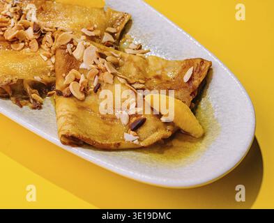 Crêpes au sirop de miel avec mendal sur fond jaune Banque D'Images