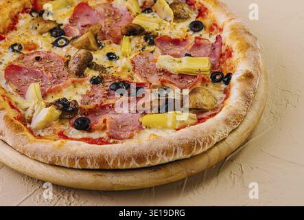 Pizza suprême fraîchement cuite garnie de divers ingrédients sur un fond neutre Banque D'Images