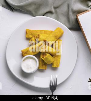 Vue de dessus de savoureux rouleaux de printemps sur une assiette avec sauce Banque D'Images