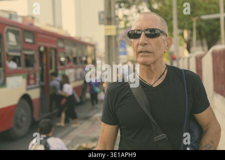 Portrait d'homme de tourisme senior chauve à l'arrêt de bus dans la ville Banque D'Images