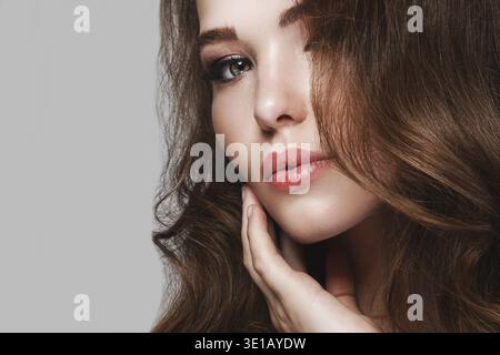Portrait de belle jeune femme avec de longs cheveux ondulés Banque D'Images