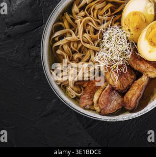 Vue de dessus d'un délicieux bol de nouilles ramen avec de succulentes tranches de porc, des œufs et des pousses Banque D'Images