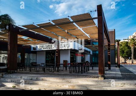 Extérieur d'un Burger King à Cartagena, Espagne. Doté d''une terrasse moderne avec une grande pergola en bois, des voiles d''ombrage et des sièges extérieurs sous un bleu Banque D'Images
