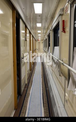 Couloir intérieur de train avec fenêtres et compartiments, mettant en valeur le voyage ferroviaire Banque D'Images