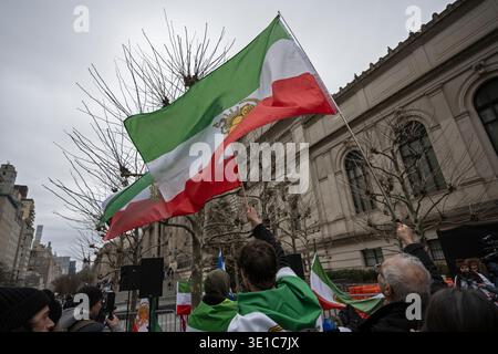 New York, New York, États-Unis. 15 mars 2026. Les gens dans la foule tiennent les drapeaux de la monarchie iranienne pendant la manifestation contre le régime islamique iranien crédit : Joseph Reid/Alamy Live News Banque D'Images