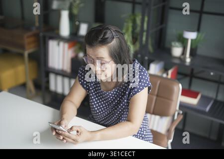 Femme senior avec téléphone intelligent pour les achats en ligne. Téléphone portable tenant dans la main Banque D'Images