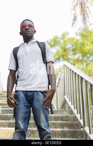 Portrait d'un jeune homme africain avec des lunettes dans les rues de la ville en plein air Banque D'Images