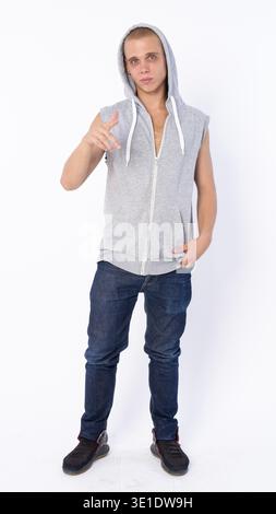 Photo de studio d'un jeune homme rebelle chauve portant une chemise à capuche isolé sur fond blanc Banque D'Images