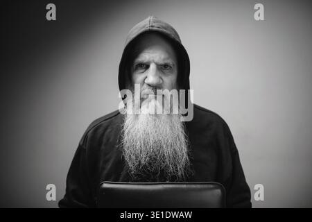Plan studio d'homme chauve mature avec une longue barbe grise sur fond blanc en noir et blanc Banque D'Images