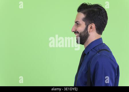Studio shot du jeune bel homme d'affaires perse barbu sur fond vert Banque D'Images