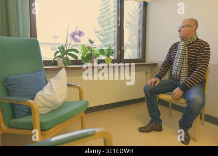 Bel homme mature en regardant par la fenêtre à la maison Banque D'Images